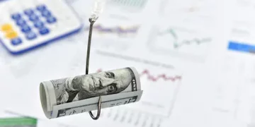 Rolled-up US dollar bill on a fishing hook over financial documents; beware of investment scams. - Supply Chain News