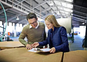 Two colleagues review HM Government's Strategic Export Controls Annual Report 2022. - Supply Chain News