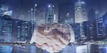 Two business people shaking hands in front of a city during the G20 Summit.