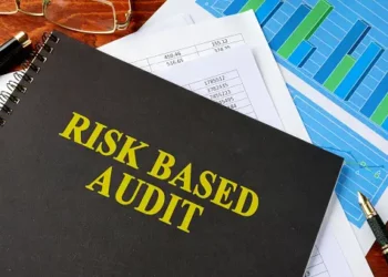 Notebook titled "Risk Based Audit" with financial documents and graphs. AICPA risk-based auditing standard. - Supply Chain News