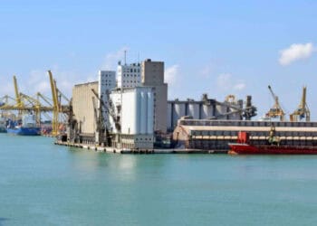 Busy port with cargo ships and industrial facilities. - Supply Chain News