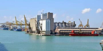 Busy port with cargo ships and industrial facilities. - Supply Chain News