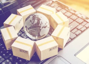 A laptop keyboard featuring a globe encircled by boxes, symbolizing America's trade policy and the concept of protectionism.
