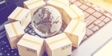 A laptop keyboard featuring a globe encircled by boxes, symbolizing America's trade policy and the concept of protectionism.