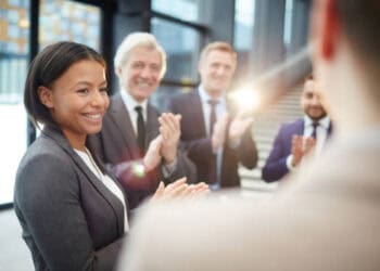 Businesspeople applauding a female colleague, celebrating success in AI risk management. - Supply Chain News