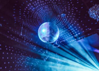 A disco ball shining brightly in the middle of a room, bringing a vibrant and energetic atmosphere reminiscent of a nightclub.