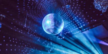 A disco ball shining brightly in the middle of a room, bringing a vibrant and energetic atmosphere reminiscent of a nightclub.