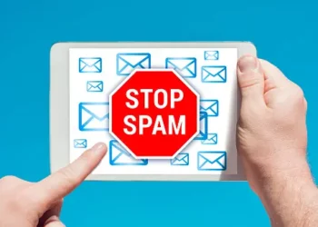 Hands holding tablet showing "STOP SPAM" sign surrounded by email icons. Combating spam calls and fraud. - Supply Chain News
