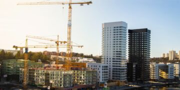 Construction site with cranes and new high-rise buildings. Sustainable development in emerging economies. - Supply Chain News