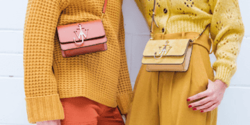 Two women wearing luxury fashion outfits, including yellow sweaters and orange pants.