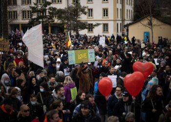Large crowd of protestors holding signs at a demonstration. - Supply Chain News