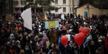 Large crowd of protestors holding signs at a demonstration. - Supply Chain News