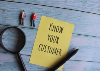 Know Your Customer: Note with miniature figures and magnifying glass. - Supply Chain News