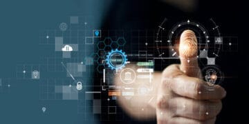 A person is pointing at a finger on a computer screen while using the GXBank Beta App for digital banking.