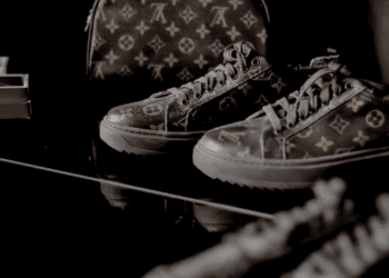 Luxury Louis Vuitton sneakers and bag on a dark surface. Challenges in the US luxury market. - Supply Chain News