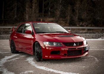 Red Mitsubishi Lancer Evolution parked outdoors. - Supply Chain News