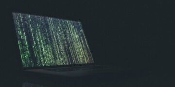 Laptop screen displaying cascading green code; reflecting the rising number of data breaches in education. - Supply Chain News