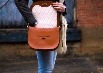 Woman with brown leather crossbody bag, featuring a quilted cream interior. - Supply Chain News