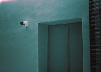 Security camera and exit sign in a modern building, reflecting new German surveillance legislation. - Supply Chain News