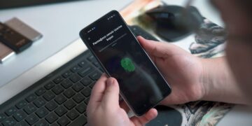 Person using fingerprint to unlock phone displaying "Parmağınızı sensör üzerine koyun" (Place your finger on the sensor). - Supply Chain News