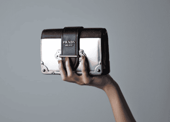 Woman's hand holding Prada Milano handbag - Supply Chain News