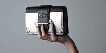 Woman's hand holding Prada Milano handbag - Supply Chain News