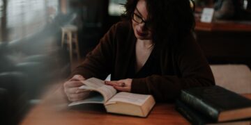 Woman studying a book, focused on UK sanctions compliance training. - Supply Chain News