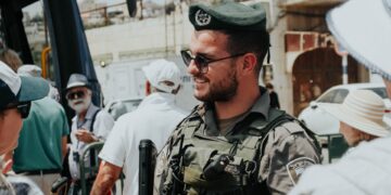 Israeli Border Police officer in uniform, sunglasses, and beret. - Supply Chain News