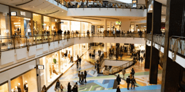 Modern luxury shopping mall interior with shoppers browsing high-end retail stores. - Supply Chain News