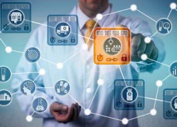 A man in a white coat is pointing at a network of technology icons.