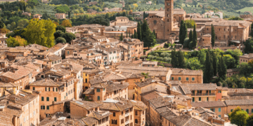 Aerial view of terracotta rooftops in Tuscany, Italy. Luxury villas and historic architecture. - Supply Chain News