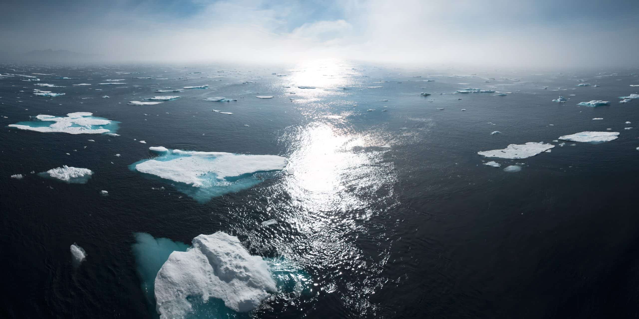 Aerial view of melting Arctic sea ice, illustrating climate change risks relevant to ESG financial reporting. - Supply Chain News