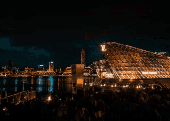 The luxurious Louis Vuitton store in Singapore, owned by French billionaire Bernard Arnault, gleams under the night sky.