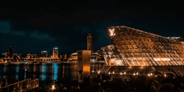 The luxurious Louis Vuitton store in Singapore, owned by French billionaire Bernard Arnault, gleams under the night sky.