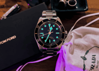 A tom ford watch and other accessories are showcased on a table in the luxury goods industry.