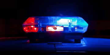 Police car with flashing blue and red lights at night. EU counterfeit operation. - Supply Chain News