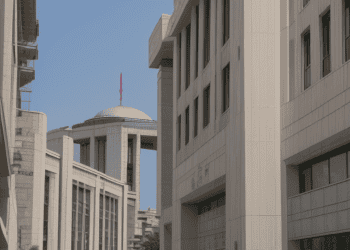A group of people walking down a sidewalk in front of Türkiye's Central Bank building.