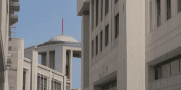 A group of people walking down a sidewalk in front of Türkiye's Central Bank building.