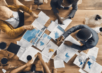 Business team analyzes global trade maps and data, discussing trade agreements and socioeconomic impacts. - Supply Chain News