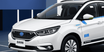 A white SUV, potentially utilized for electric vehicle marketing, is parked in a room.