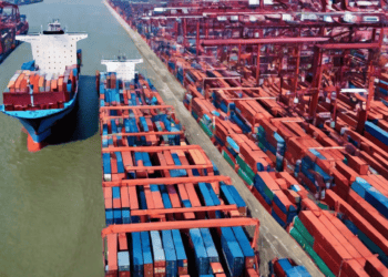 A large container ship docked at a port, highlighting the impact of Global Supply Chain Crisis on Shipping Companies' Profits.