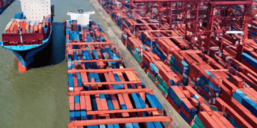 A large container ship docked at a port, highlighting the impact of Global Supply Chain Crisis on Shipping Companies' Profits.