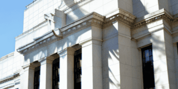A white building with a clock on it, representing the U.S. Federal Reserve.