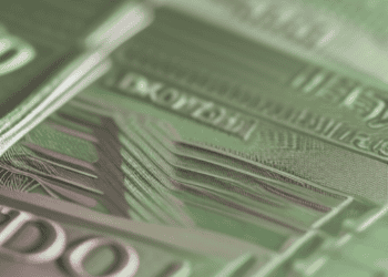 A close up of a stack of green banknotes highlighting the impact of the BOE Rate Cut on Sterling's decline.