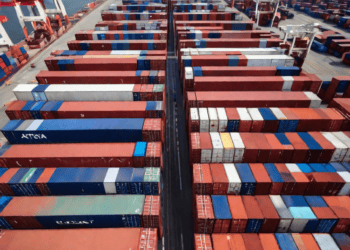 Aerial view of numerous shipping containers at a busy port, illustrating global supply chain logistics. - Supply Chain News