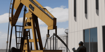 A man standing in front of an OPEC+ oil pump, working to stabilize oil prices.