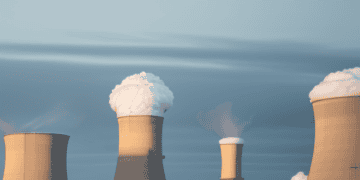 A group of cooling towers used in nuclear energy production, facing challenges in adopting new technologies.