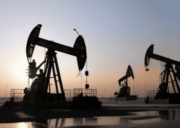 Oil pumps on the beach at sunset amidst middle east tensions.