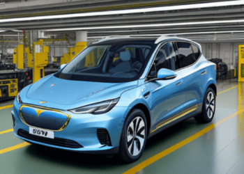 A blue electric car, affiliated with Tata Group, is parked in a factory.