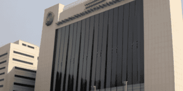 Nigeria's Central Bank, led by Emefiele, stands as a large white building with a flag on it.